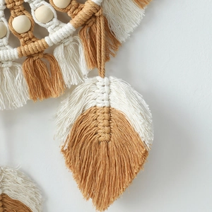 Close-up of bohemian macramé wall decor with handmade cotton tassels and wood beads