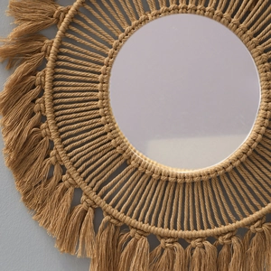 Close-up detail of bohemian woven macrame wall mirror featuring cotton fringe texture