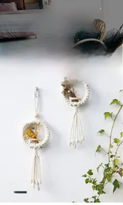 Detail of bohemian macrame wall hanging with dried flowers and wooden beads