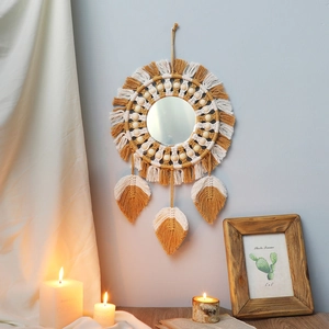 Detail of bohemian woven mirror with yellow tassels, wooden beads and macrame leaf pendants