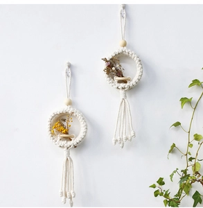 Detail of bohemian handmade woven wall hanging featuring cotton rope and natural dried flowers