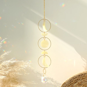 Detail of crystal suncatcher with golden moon phases and a multifaceted crystal sphere