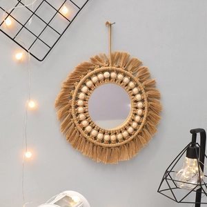 Detail of bohemian round wall mirror with brown macrame fringe and wooden beads