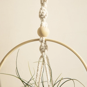 Detail view of handmade macrame air plant hanger with cotton rope and wooden bead