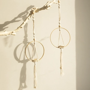 Macro detail of handmade macrame hanging planter with woven cotton rope and wood ring