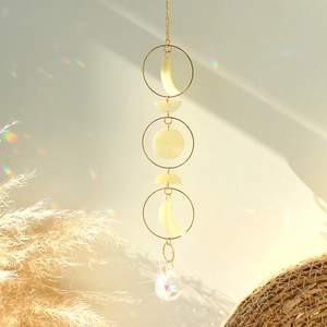 Celestial suncatcher with moon phases, gold rings, and a crystal prism pendant for home decor