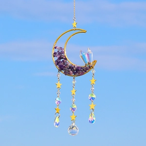 Detail of moon suncatcher with purple amethyst stones and crystal prisms under a blue sky