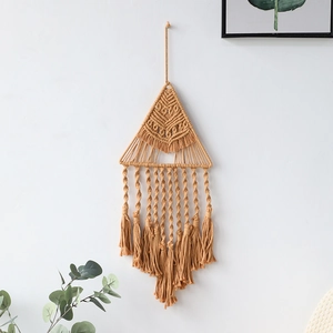 Dettaglio dell'arazzo boho tessuto a mano con nappe geometriche in corda di cotone