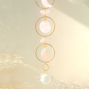Detail of moon phase suncatcher featuring pink resin moon and sparkling crystal prism ball
