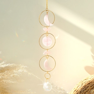 Detail of moon phase suncatcher with pink acrylic accents and a faceted crystal ball prism