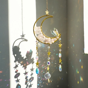 Macro shot of moon crystal suncatcher reflecting rainbow light spots on wall
