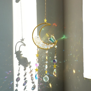 Macro detail of moon suncatcher showing golden frame and rainbow prism light reflections