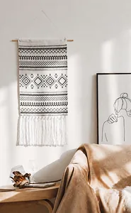 Close-up of bohemian wall tapestry with geometric patterns and dense white fringe tassels