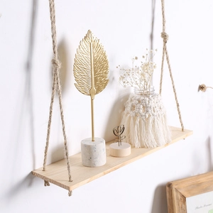 Close-up of bohemian wooden hanging shelf with natural jute rope and decorative items