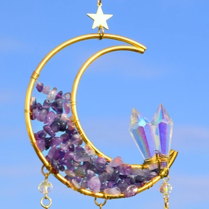 Close-up of crescent moon suncatcher with amethyst chips and crystal prisms against sky