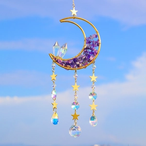 Detailed close-up of golden moon suncatcher with purple amethyst crystals against blue sky