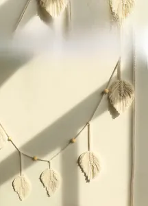 Detail of bohemian handmade cotton leaf wall hanging with natural wooden beads