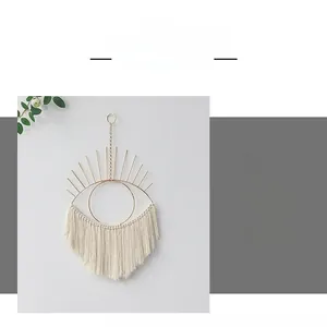 Detailed close-up of handmade macrame Evil Eye wall hanging with golden metal ring and fringes
