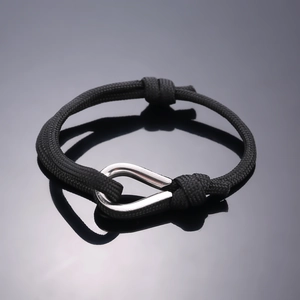 Adjustable black woven bracelet featuring a polished silver U-shaped metal shackle clasp