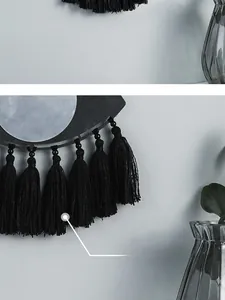 Détail d'un miroir mural bohème avec des glands minimalistes en soie noire élégante