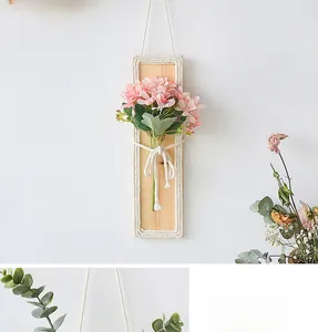 Detail of handmade woven wall decor with pink artificial flowers on a wooden plaque