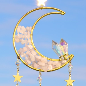 Detail of crescent moon suncatcher with rose quartz stones and iridescent crystals