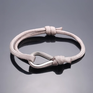 Pink braided rope bracelet with silver horseshoe buckle in a minimalist outdoor style