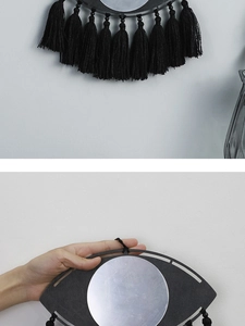 Détail d'un miroir mural bohème œil protecteur avec pompons noirs et détails perlés