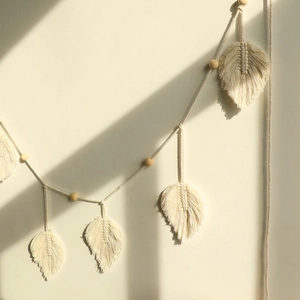 Bohemian handmade cotton maple leaf wall hanging with wooden beads on beige wall