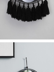 Vue détaillée d'une décoration murale bohème à pompons noirs avec texture tissée et franges