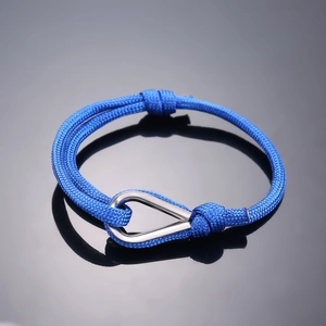 Adjustable dark blue braided cord bracelet with a polished silver horseshoe buckle