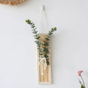 Bohemian wall hanging with faux eucalyptus greenery on light wood panel with braided rope
