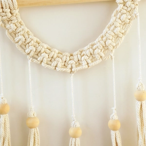 Detail of bohemian handmade woven wall hanging featuring intricate cotton knots and wood beads