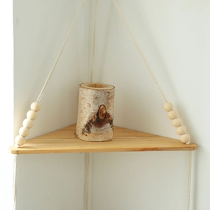 Macro view of Bohemian triangle wood corner shelf with cotton rope and beads detailing
