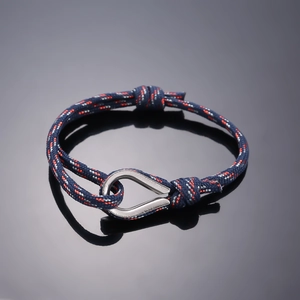 Adjustable navy woven rope bracelet with red and white accents and steel pear clasp