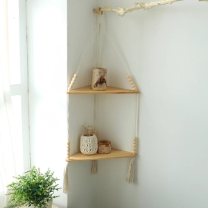 Detail of bohemian wooden corner shelf with macrame ropes and decorative fringe tassels