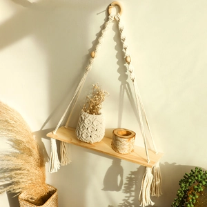Detail of bohemian handmade woven shelf with wood beads and long cotton rope tassels