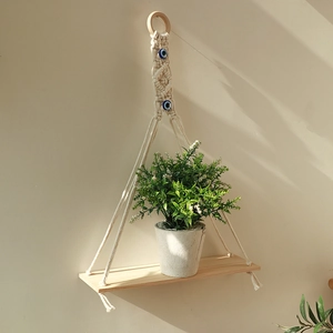 Bohemian macrame wall hanging shelf with evil eye beads and natural wooden plank