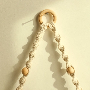 Detail of bohemian handmade macrame plant hanger with spiral knots and natural wood beads