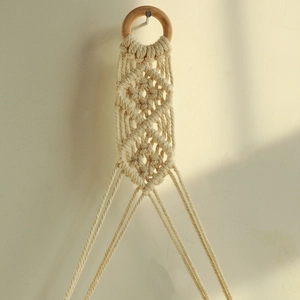 Close-up of bohemian handmade cotton rope weave and wooden ring wall hanging