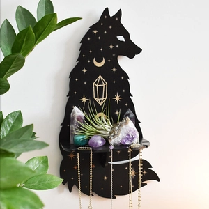 Detail of wolf shaped wooden wall shelf with gold moon stars and hanging necklaces