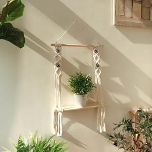 Bohemian handmade macrame wall shelf with evil eye beads and natural wood plant holder