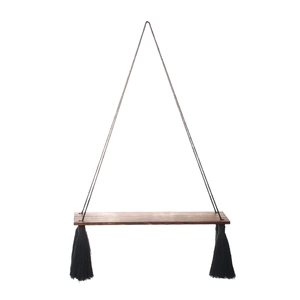 Detail of bohemian wood shelf with black tassels and triangle hanging structure