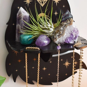 Detail of black wooden crystal display shelf with golden mystic moon and star patterns