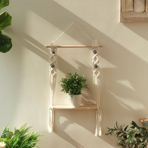 Detail of bohemian woven wall shelf with evil eye beads and natural wooden plank