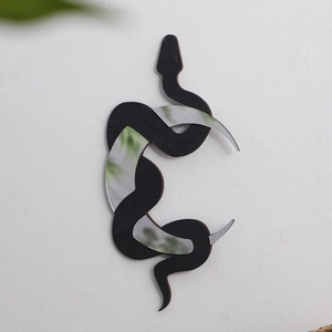 Modern black snake wall hanging mirror decoration with crescent moon motif on white wall