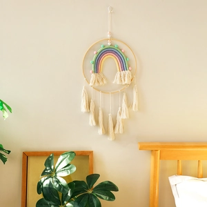Detail of bohemian rainbow wall hanging with cotton fringe and natural wood ring