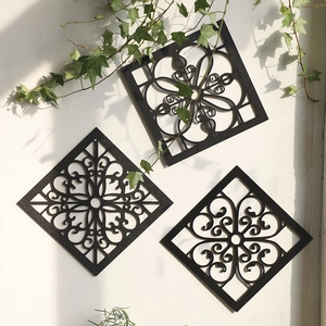 Macro detail of three-piece black wood wall art with intricate mandala cutout patterns