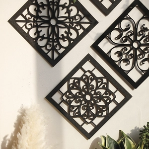 Macro detail of laser-cut black rhombic wall decor with intricate European scroll patterns