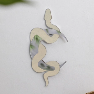Detailed close-up of a crescent moon and snake mirror wall sticker in gold and silver